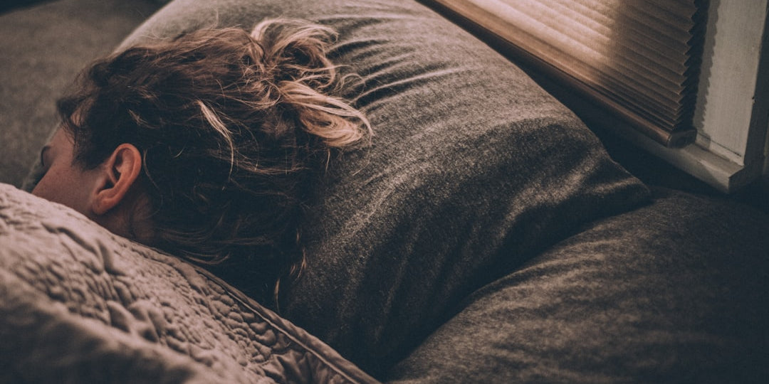 Woman sleeping on gray bedding
