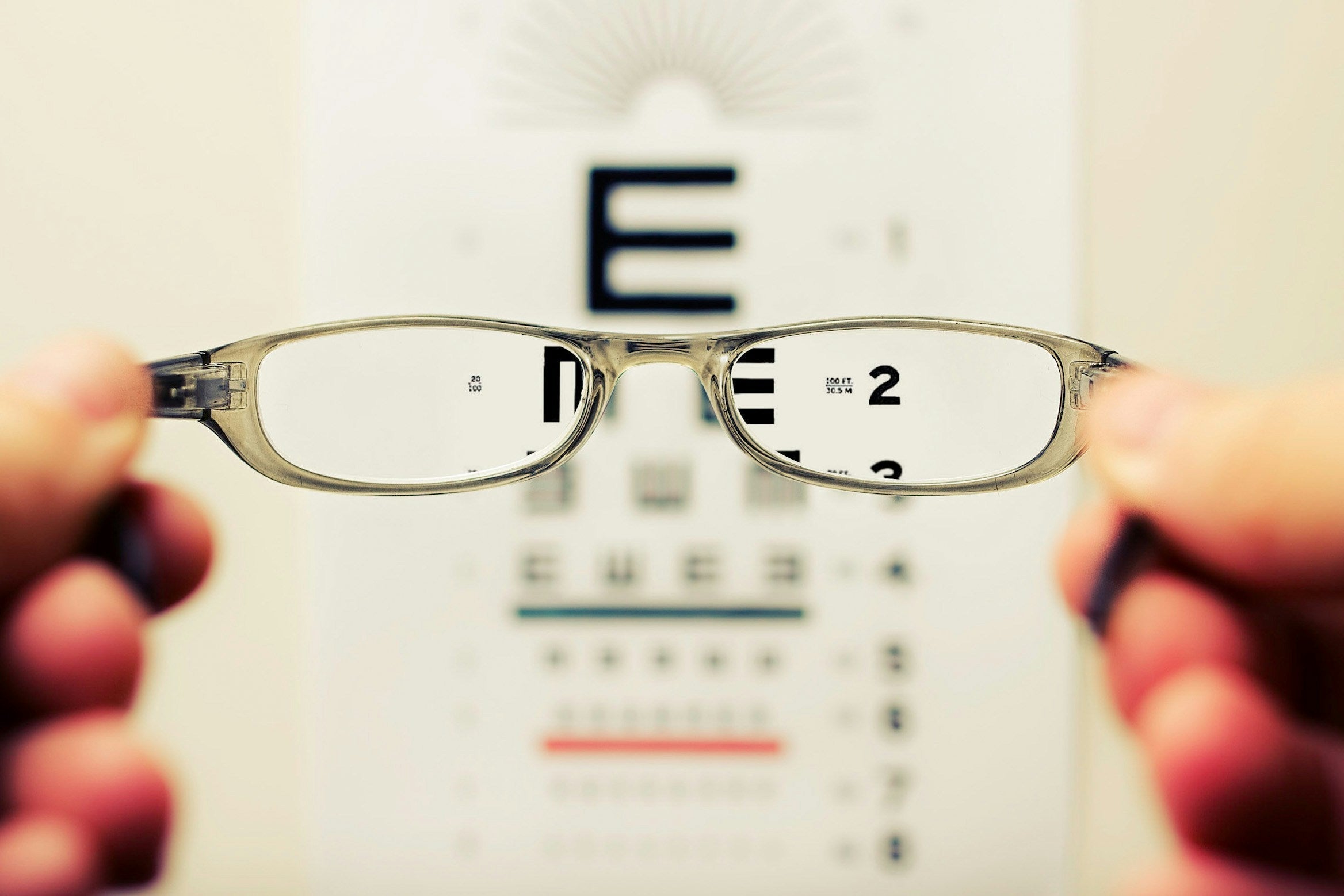 Eyeglasses held up to an eye test chart