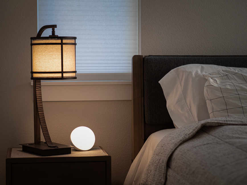 Lamp and glowing orb beside bed