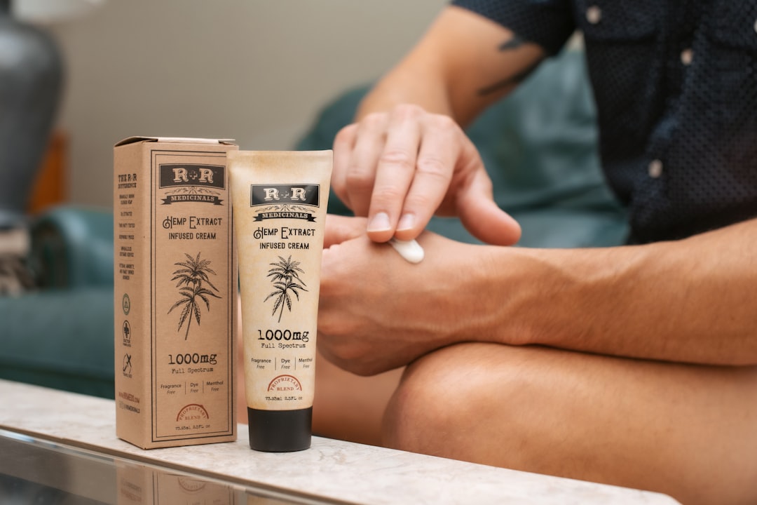 Person applying hemp extract cream to hand
