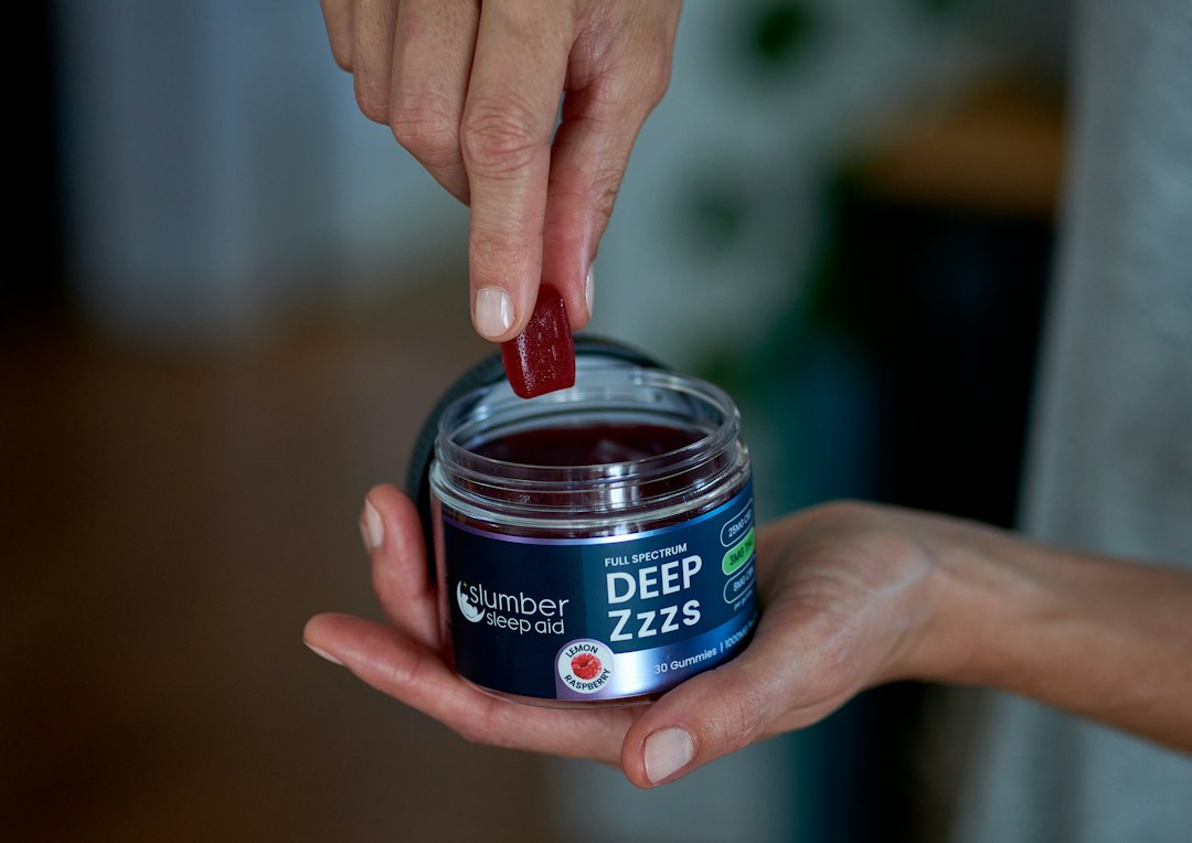 Person picks gummy from Deep Zzzs jar