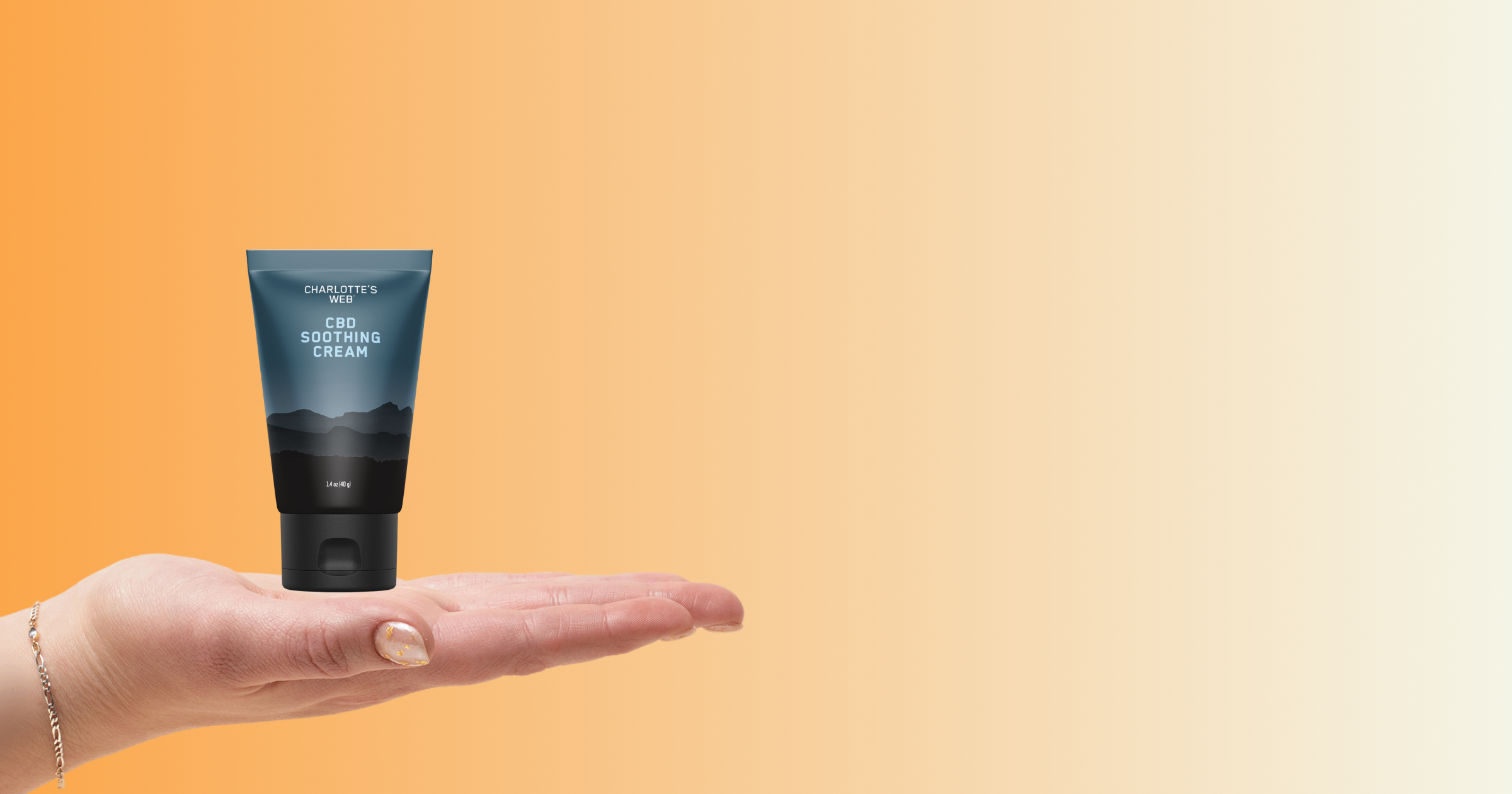 Hand holding a tube of soothing cream against an orange gradient background