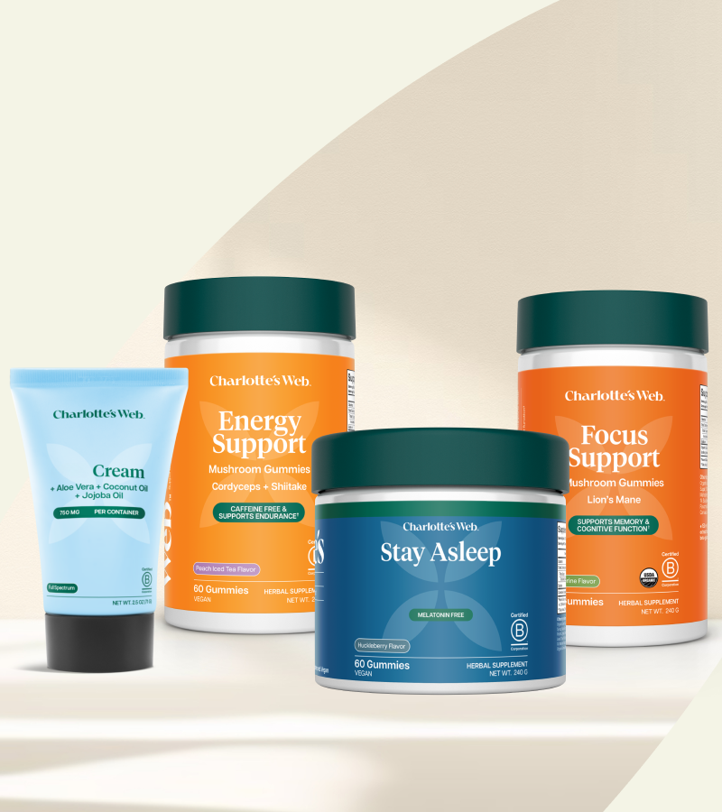 Collection of Charlotte's Web health products including cream, energy support, focus support, and stay asleep on a beige background.