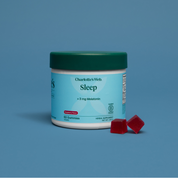 Product Image for Jar of Charlotte&#39;s Web Sleep gummies with two red gummies on a blue background