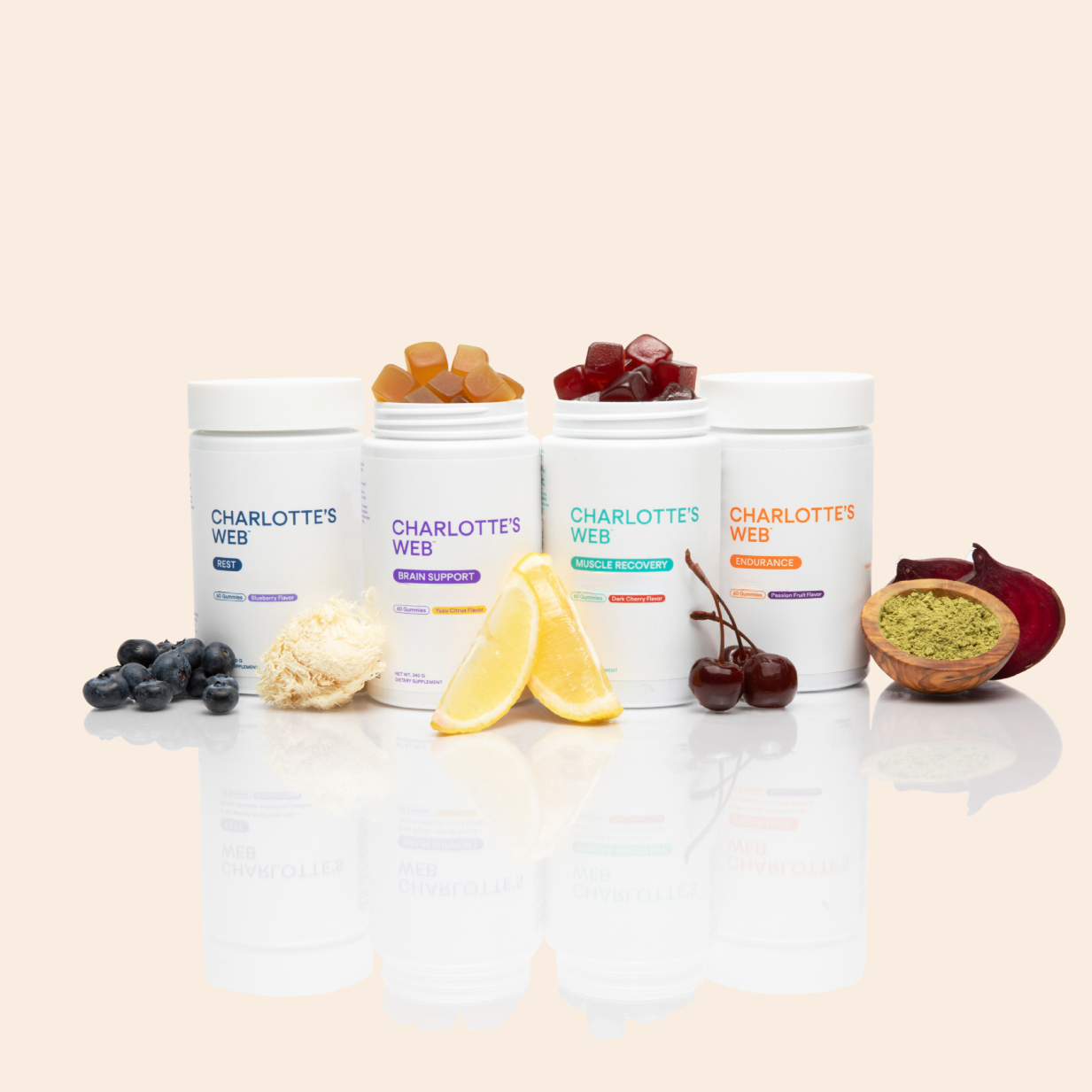 Product Image for Four containers of Charlotte&#39;s Web products on a reflective surface with various snacks.