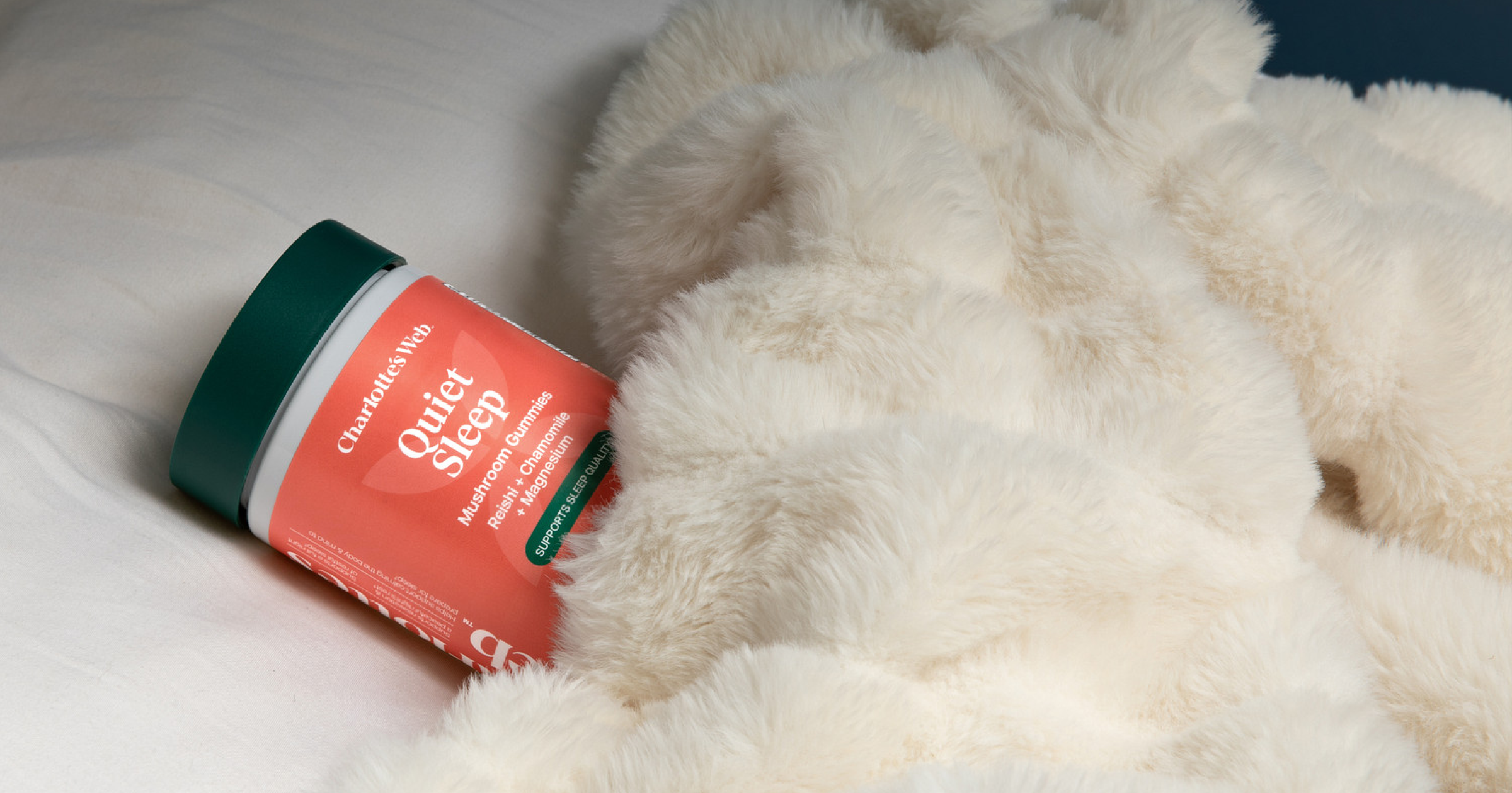 Jar of 'Quieter Sleep' supplement on a fluffy white blanket