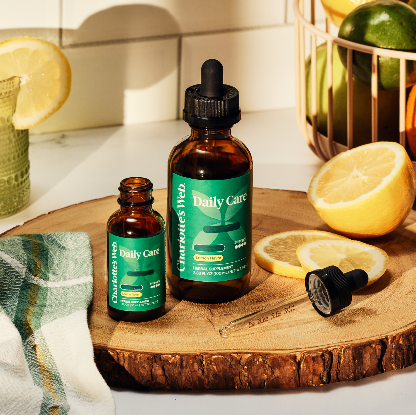 Product Image for Two bottles of 'Daily Care' supplement on a wooden surface with lemons and a towel.