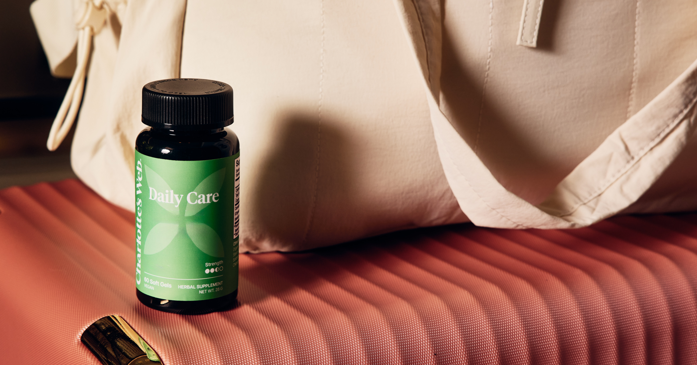 Bottle of 'Body Care' on a textured surface with a beige bag in the background