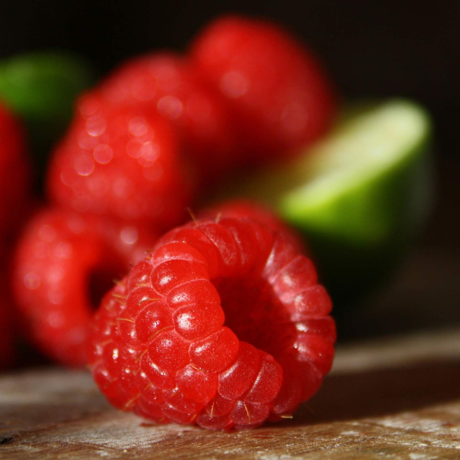 Product Image for Close-up of red raspberries on a wooden surface with a blurred background