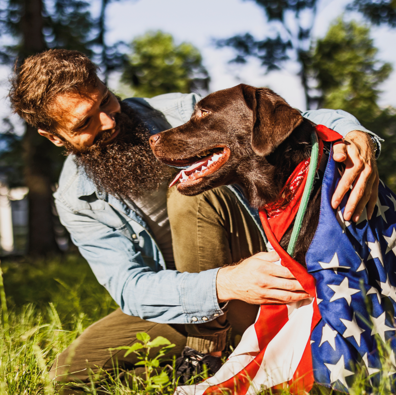 Man with a dog holding an American flag