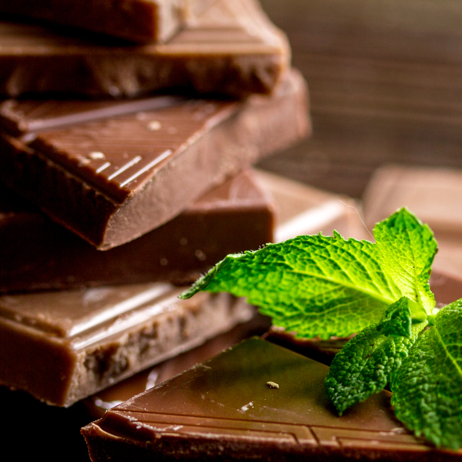 Product Image for Stack of chocolate bars with a mint leaf on a wooden surface