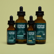Product Image for Four bottles of Charlotte&#39;s Web Original Formula herbal supplement on a light green background