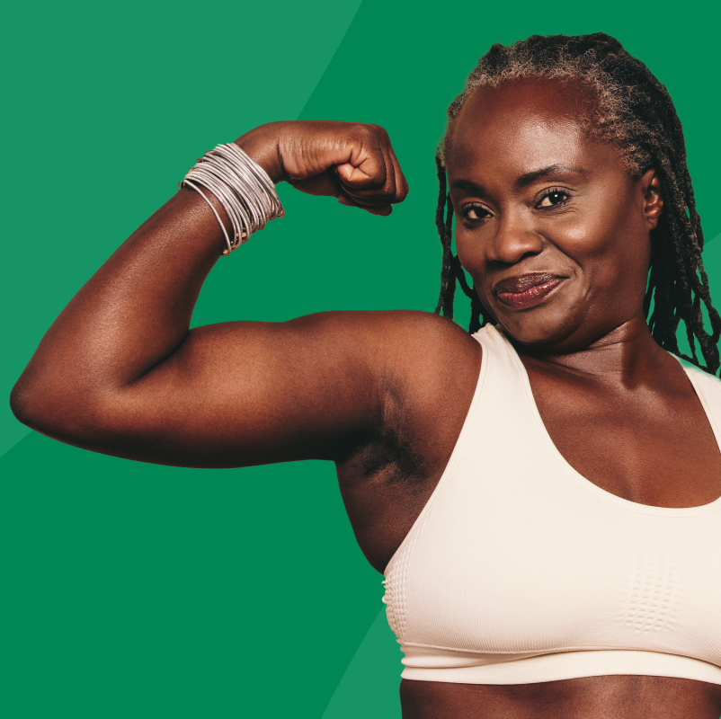 Woman flexing her arm muscles on a green background